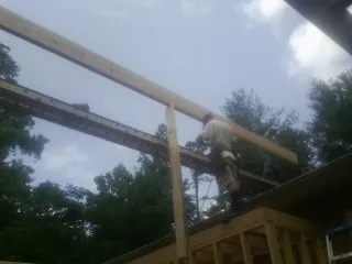 Carpenter setting a ridge beam over a new addition frame — Ice Dam Removal by Roofing Brothers in River Falls