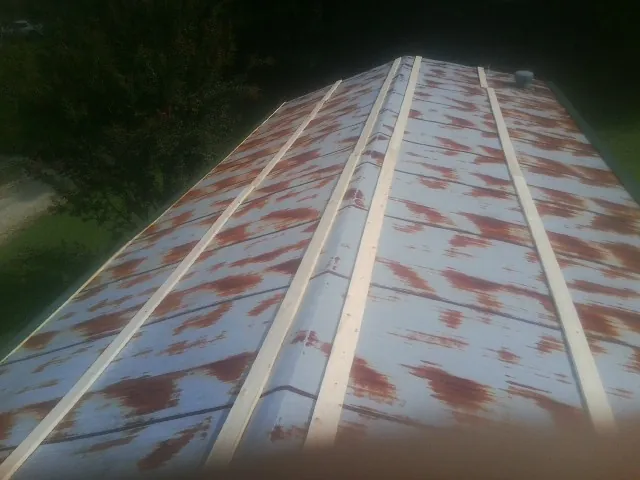 Rusted metal roof panels with new wood purlins before replacement — Storm Damage Roof Repair in River Falls by Roofing Brothers