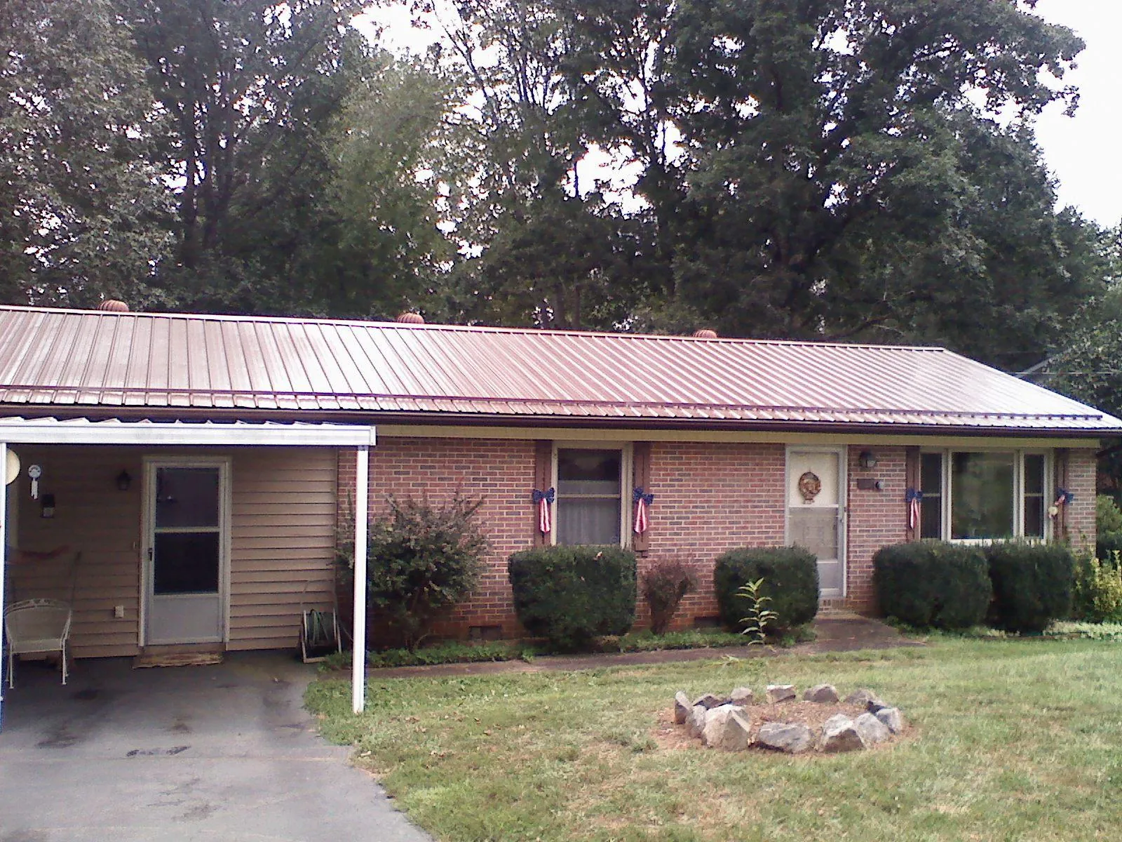 Bronze metal roof and carport on a brick ranch home — Roof Repair work by our crew in River Falls