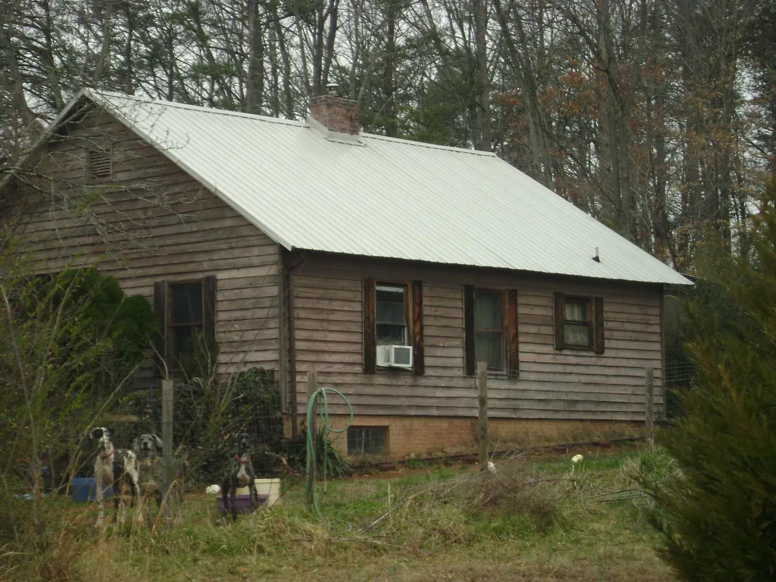 White metal roof on an old wood sided farmhouse, from a Metal Roof Installation job in River Falls